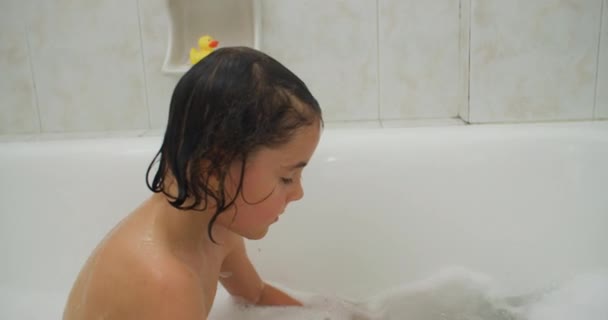 아이는 집에서 목욕하는 장난감과 재생합니다 여자는 거품으로 목욕에서 고품질 — 비디오