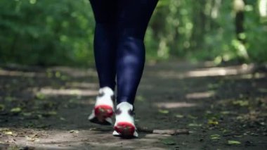 Kucaklayan Doğa Güzelliği: Hareketli Kız Serene Park Patikaları boyunca koşuyor. Yüksek kalite 4k görüntü