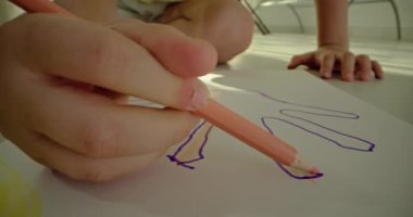 Albümdeki bir kalemle Childs 'ın el çizimine yakın plan. Çocuk evde sanatla meşgul, resim çiziyor, okula hazırlanıyor. Yüksek kalite 4k görüntü