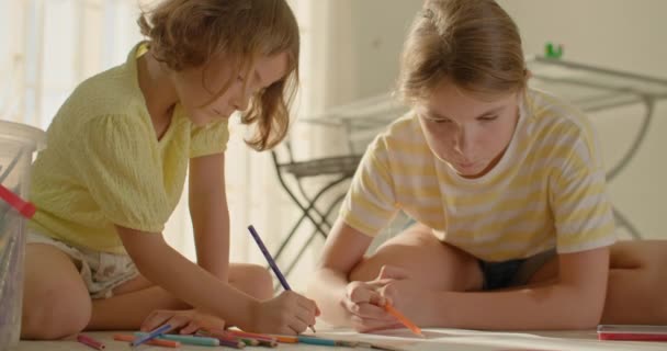 Δύο Αδερφές Ζωγραφίζουν Μολύβια Στο Σπίτι Στο Σαλόνι Στο Πάτωμα — Αρχείο Βίντεο