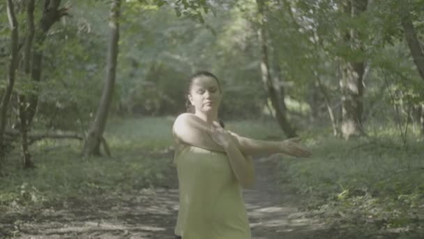 在公园慢跑之前 漂亮的超重加身材的女孩已经准备好了 热身了 一个女人在森林里跑步时体重减轻 高质量的4K镜头 — 图库视频影像