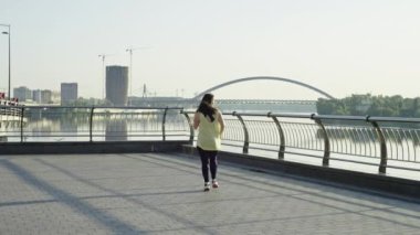 Kafkas atletik kız sabah koşusunu şehir manzarasında tamamlıyor. Şehrin sokaklarında koşan bir kadın işkence görüyor ve terliyor, şehir sporu. Yüksek kalite 4k görüntü