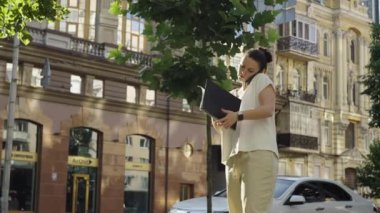 Profesyonel Kadın İş Başında: Telefon Konuşmaları ve Şehir İş Merkezinde Ofis Yürüyüşü. Yüksek kalite 4k görüntü