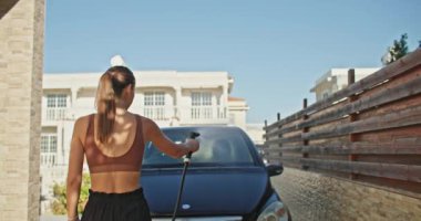 Titiz Araba Bakımı: Kararlı Kadın, Arabasının Yaklaşan Yolculuk İçin En İyi Durumda Olmasını Sağlama Aldı. Yüksek kalite 4k görüntü