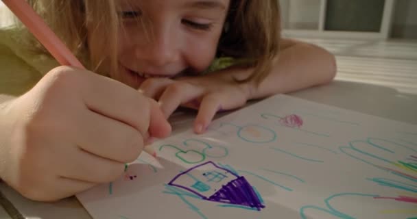 女の子はアルバムに紙に鉛筆で家を描いている ユーラシアの子供 家族の幸福 愛と芸術の概念 高品質の4K映像 — ストック動画