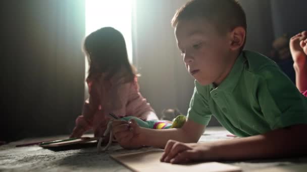 スウィートシブリング 兄弟と姉妹 芸術探査に従事 リビングルームの床にカラフルな鉛筆で遊び心のあるスケッチ 高品質の4K映像 — ストック動画