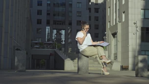 Takım Elbiseli Ciddi Bir Kadın Merkezinin Yakınında Sokakta Telefonla Konuşuyor — Stok video