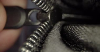 Ceketi fermuarla kapatan bir adamın eli. Giysilerin kilitle kapatıldığı yakın çekim video. Yüksek kalite 4k görüntü