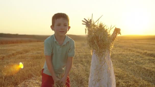 日没に干し草を投げる笑顔の子供たち 男の子と女の子は小麦の農場で楽しんでいます 高品質の4K映像 — ストック動画