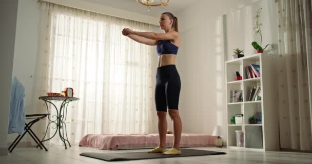 这个女孩在客厅里做健身锻炼 在家里刻苦训练 努力锻造苗条身材 积极运动的生活方式 高质量的4K镜头 — 图库视频影像