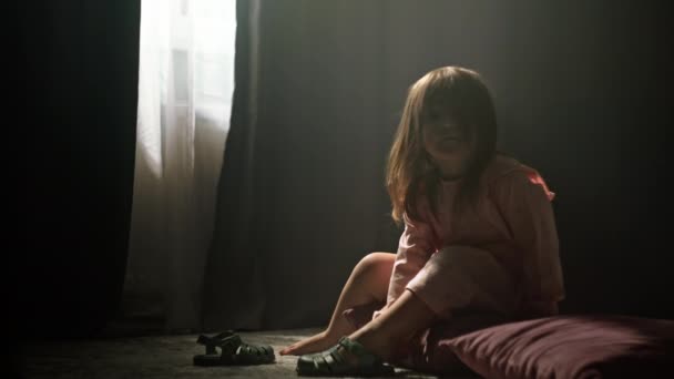 子供の少女は 自宅の床に座っている靴を履いています 子供は外で散歩するための服を着ます 高品質の4K映像 — ストック動画