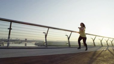 Şehir manzarasında sabah koşusuna çıkmış kilolu bir kız. Koşarak kilo veren bir kız, bir fikir. Aktif spor ve spor bir yaşam biçimidir. Yüksek kalite 4k görüntü