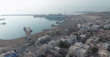 Kıbrıs Rum Kesimi 'nin Larnaka kentinin havadan görünüşü. Deniz kıyısında iş merkezleri, toprak setleri ve otelleri olan bir şehir manzarası. Yüksek kalite 4k görüntü