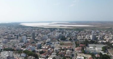 Larnaca 'nın havadan görünüşü, Kıbrıs' ın arkasında Salt Lake. Şehrin gölü, doğası, evleri ve caddeleri olan güzel bir manzara. Yüksek kalite 4k görüntü