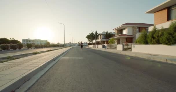 晨曦健身套路 积极参加晨跑的女性穿着运动服穿过城市环境 高质量的4K镜头 — 图库视频影像