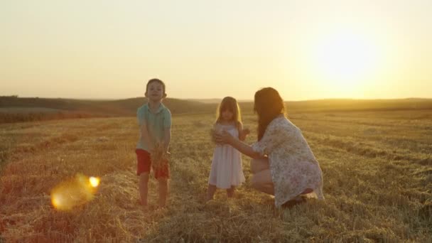 母親と一緒にいる陽気な子供たちは 干し草を投げ 農場で幸せな家族が集まってくる 高品質の4K映像 — ストック動画