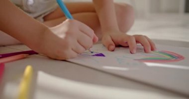 Çocukların evi kavramı sevgi ve mutluluktur. Küçük kız bir albümde kalemlerle bir ev inşa ediyor. Yüksek kalite 4k görüntü