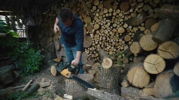 一个人开始用链锯锯木柴 伐木工人在农场收割木柴的辛苦劳动 高质量的4K镜头 — 图库视频影像
