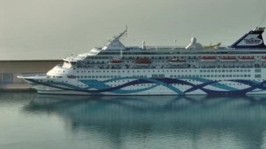 Yolcu gemisi Luxari 'nin deniz seyahatinin havadan görüntüsü. Limanda yüzme havuzları ve kulübeleri olan bir gemi duruyor. Yüksek kalite 4k görüntü