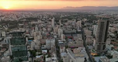 City Heights: Nicosias İş Bölgesi ve Sunset 'teki Kentsel Manzara. Yüksek kalite 4k görüntü