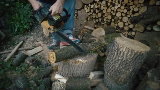 チェーンソーでログを切った男のスローモーションクローズアップビデオ 村の農場で薪を採取する 高品質の4K映像 — ストック動画