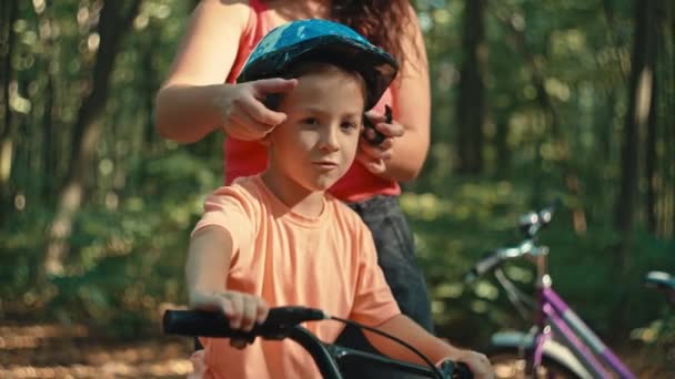 Mamá Pone Hijo Casco Bicicleta Protectora Parque Mientras Monta Protección — Vídeos de Stock