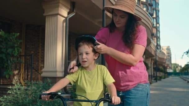 Мать Надевает Защитный Шлем Своего Сына Перед Поездкой Велосипеде Ребенок — стоковое видео
