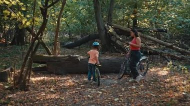 Mutluluk ve Beraberlik Günü: Anne ve Oğlu Parks Doğal Görkemi 'ne Daldırıyor, Ahenk içinde Bisiklet Sürüyor. Yüksek kalite 4k görüntü