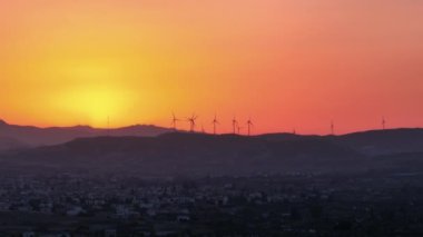 Sürdürülebilirliği kucaklayan: Doğanın Gücü 'nü kullanan Sunset' teki Dağ Sırası 'ndaki Rüzgar Çiftliği. Yüksek kalite 4k görüntü