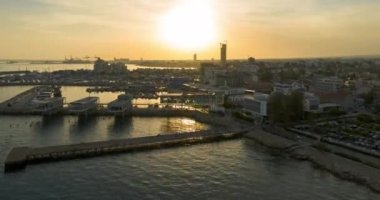 Gün batımında deniz kenarındaki şehir manzarasının havadan görüntüsü. Lüks otelleri ve kentsel manzarası olan bir adada güneşli bir şehir hayatı. Yüksek kalite 4k görüntü