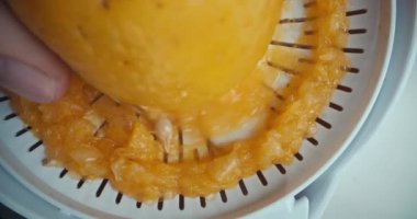 Mutfaktaki taze portakalların meyve sıkma suyunu sıkma videosu. Bir kadının eli narenciye meyvesine bastırır. Yüksek kalite 4k görüntü