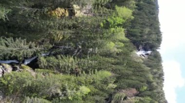 Alplerdeki bir şelalenin havadan görünüşü. İnanılmaz doğal bir manzarada dağ yamaçları ve nehirleri olan güzel bir doğa. Yüksek kalite 4k görüntü