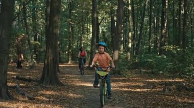 Mutlu aile ormanda birlikte bisiklete biniyor. Anne ve oğlu hafta sonları aktif olarak rahatlar, bisiklet sürmeye giderler. Yüksek kalite 4k görüntü