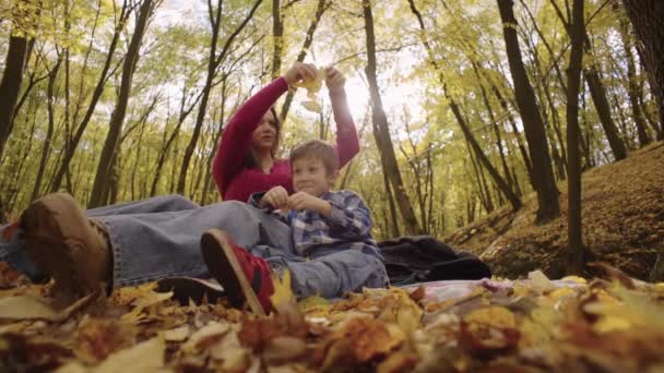 Matka Syn Pikniku Jesiennym Lesie Kobieta Rzuca Żółte Liście Spacer — Wideo stockowe