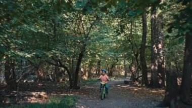 Çocukluk Neşesi: Koruyucu Vitesli Çocuk Bisikletiyle Parkı Keşfediyor. Yüksek kalite 4k görüntü