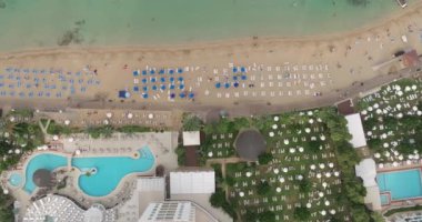 Kıbrıs adasındaki otellerle birlikte havadan deniz seti. Plajları ve lüks daireleri olan güzel bir sahil şeridi. Yüksek kalite 4k görüntü