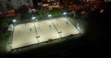 Şehirdeki plaj voleybol sahalarının kentsel manzarası. Şehir merkezindeki gece limanında oyun parkları. Yüksek kalite 4k görüntü