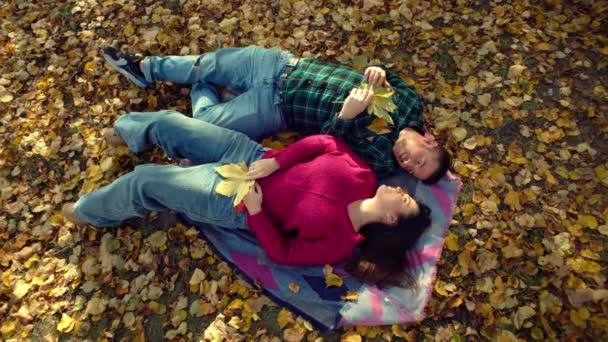 恋するカップルは 秋の公園で黄色い葉を投げます ロマンスと家族の幸せと暖かさ 愛と笑顔のコンセプト 高品質の4K映像 — ストック動画