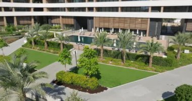 Bahçesinde palmiye ağaçları ve havuzu olan yüksek teknolojili bir apartman. Modern mimari. Yüksek kalite 4k görüntü