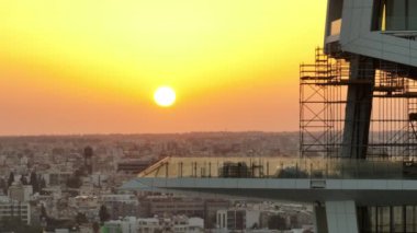 Hava manzaralı şehir günbatımı. Güneş ışınlarıyla inşa edilen bir evin kentsel manzarası. Yüksek kalite 4k görüntü