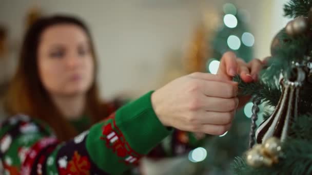 クリスマスツリーに飾りを吊るす少女のクローズアップ 自宅の白人女性の休日と新年の雰囲気は部屋を飾っています 高品質の4K映像 — ストック動画