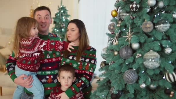 休日のために家のクリスマスツリーの近くで幸せな家族の肖像画 子供と親は笑顔で 新年に喜んでいる 人生の母親 暖かさと愛 高品質の4K映像 — ストック動画