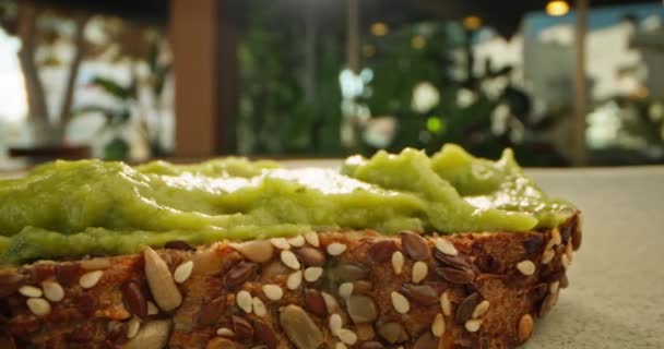 Makro Slow Motion Video Att Sprida Guacamole Bröd Hälsosam Frukost — Stockvideo
