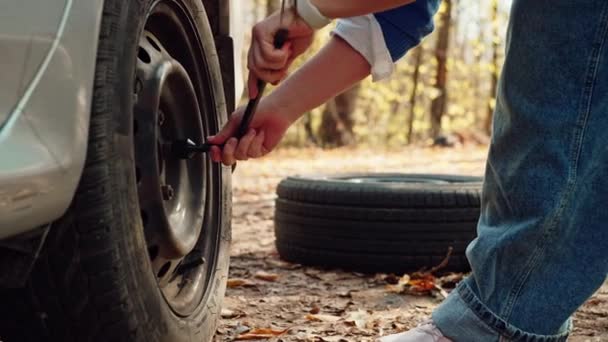 一个女人的手拿开车胎上一个破轮胎的特写镜头 汽车故障和旅行中的麻烦 高质量的4K镜头 — 图库视频影像