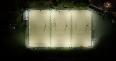 Akşam Oyun Alanı: Şehir Hayatı ve Gece Gökyüzü Altındaki Kum Voleybol Oyunları 'nın Hava Görüntüleri. Yüksek kalite 4k görüntü