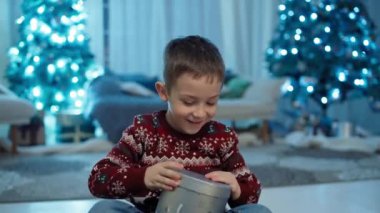 Neşeli Şenlik: Gülümseyen, Etkileyici Çocuk Noel Baba 'dan Şenlikli Firavun' un altındaki hediyeyi açıyor. Yüksek kalite 4k görüntü