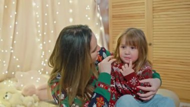 Sihirli anlar: Anneler Noel arifesinde çocuklarla oynaşıyor, Yeni Yıl Anıları yaratıyor. Yüksek kalite 4k görüntü