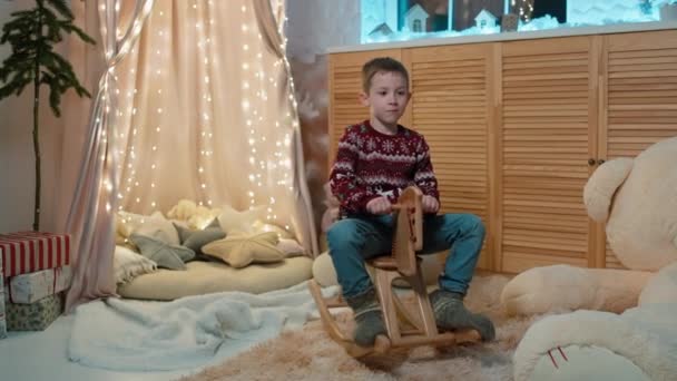 Hyvää Lomaa Hauskaa Onnellinen Hymyilevä Lapsi Leikkii Jouluaiheisessa Huoneessa Ratsastaa — kuvapankkivideo