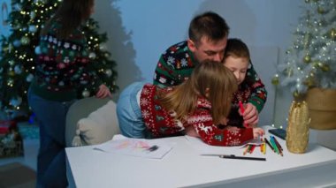 Noel Rüyaları Açılışı: Anne ve Baba, Noel Baba 'ya Noel Baba' ya Dekorasyon Ağacının Yanında Mektuplar Yazmada Çocuklara Yardım Ediyor. Yüksek kalite 4k görüntü