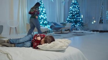 Neşeli Zevk: Anne Uyuyan Bir Çocuk İçin Hediyelerle Noel Büyüsü Yapıyor. Yüksek kalite 4k görüntü